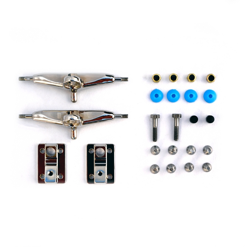 The Deli Trucks Raw hardware set by tiny skateshop includes two silver trucks, screws, nuts, washers, and two black baseplates with blue and black bushings. All components are neatly arranged on a white background.